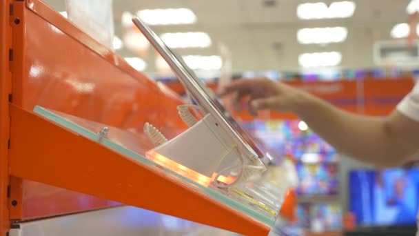 L'acheteur dans le magasin d'électronique choisit un nouveau gadget. 4k, gros plan, fond flou. Vous cherchez une nouvelle paix de gadget . — Video