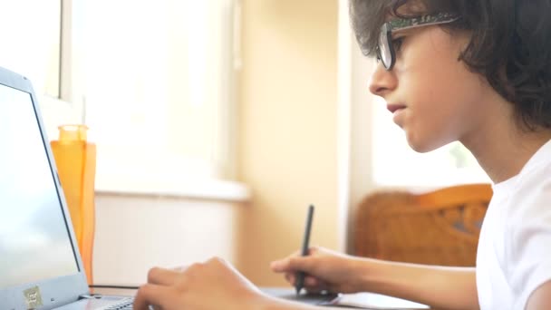 Bir grafik tablet üzerinde çalışan yakışıklı modern çocuk genç. dizüstü bilgisayar ekranında görünüyor. 4k, ağır çekim — Stok video