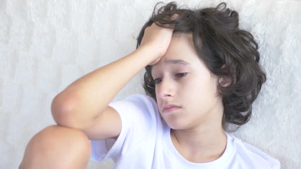 Retrato de un triste adolescente cansado que se sienta en el sofá. 4k — Vídeos de Stock