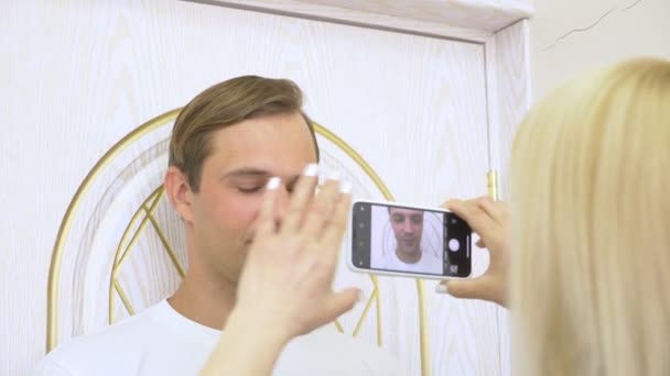 De arts neemt een foto van een gezicht van jonge personen vóór de contouren procedure. foto voor en na. 4k, slow-motion — Stockvideo