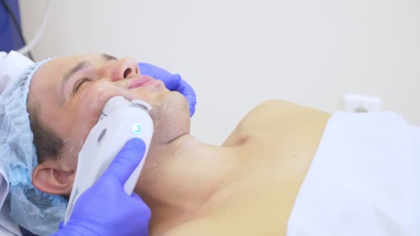 Levantamento facial não cirúrgico. SMAS levantando ultra-som. O processo de rejuvenescimento. Cosmetologia de hardware. contorno de plástico rosto. mãos de um dermatologista médico fazer um homem um ultra-som facelift — Vídeo de Stock