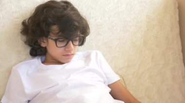 sevimli kıvırcık genç kanepede uyuyor. Uyku eksikliği. yakın çekim, 4k.