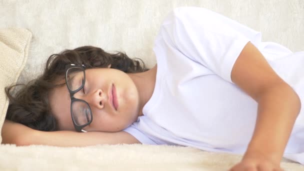 Милый кудрявый подросток спит на диване. Недостаток сна. макро, 4k — стоковое видео