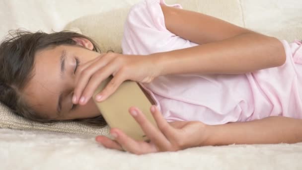 Menina adolescente bonito dormindo no sofá com telefone na mão. Falta de sono. close-up, 4K — Vídeo de Stock