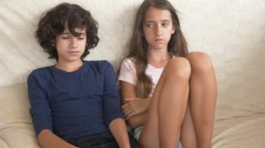 Gençler, İkizler, kardeşi ve kız kardeşi, kavga kanepede oturuyor. 4 k, ağır çekim, yakın çekim.