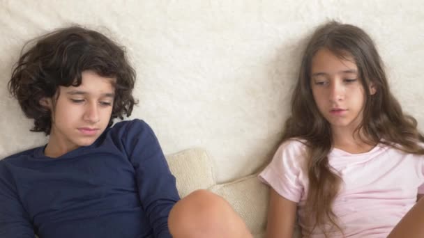 Adolescentes, gemelos, hermanos y hermanas pelean, sentados en el sofá. 4k, cámara lenta, primer plano . — Vídeos de Stock
