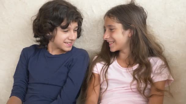 Retrato de adorable hermano y hermana, adolescentes sonriendo y riendo con expresión divertida en sus rostros. Felicidad y relaciones familiares. 4k, cámara lenta — Vídeos de Stock