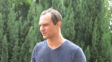 Yağmur, ağır çekim ayakta hüzünlü adam. yağmur akışı hoşnutsuz bir adamın yüzü aşağı bırakır. 4k