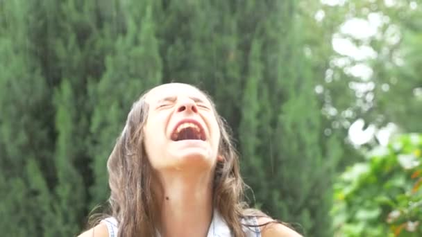 Verdrietig meisje brunette met lange haren draagkracht in de stromende regen zonder paraplu. Close-up, 4k, slow-motion — Stockvideo