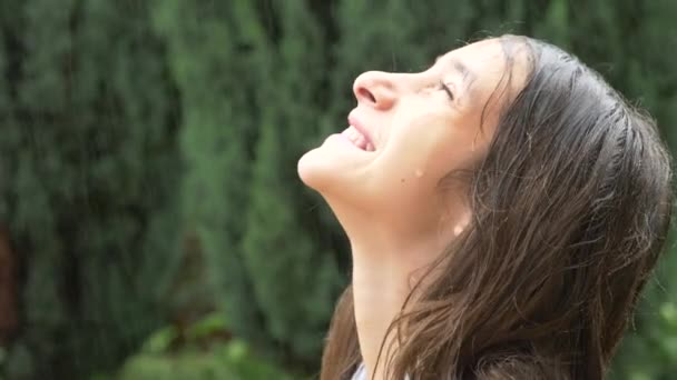 クローズ アップ。濡れた髪で雨の中、自然を見て若い女の子の肖像画。少女は、彼女の顔に落ちる水の滴土砂降りの雨で高慢します。4 k. スローモーション — ストック動画