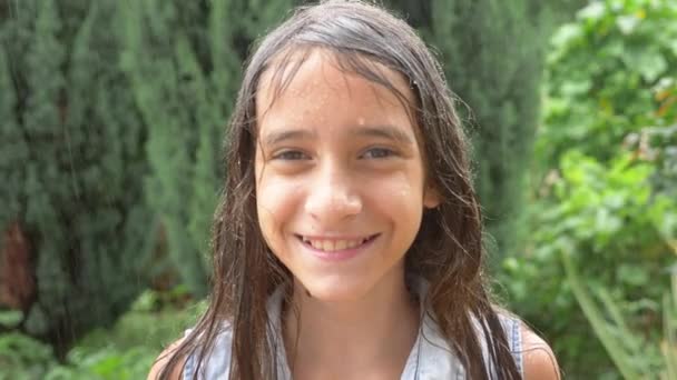 Primer plano. retrato de una joven mirando la lluvia en la naturaleza con el pelo mojado. la muchacha se regocija en la lluvia torrencial, gotas de agua caen sobre su rostro. 4k. Movimiento lento — Vídeos de Stock