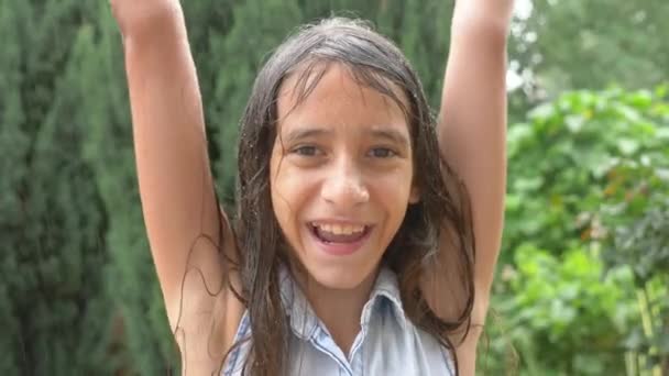 Close-up. retrato de uma jovem olhando para a chuva na natureza com o cabelo molhado. a menina se alegra com a chuva torrencial, gotas de água caem em seu rosto. 4K. Movimento lento — Vídeo de Stock