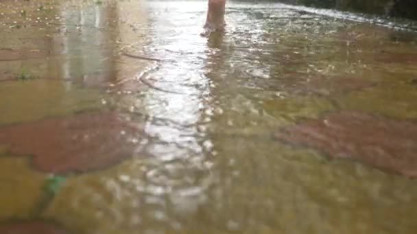 Летний дождь. Босые ноги бегут через лужу. Теплый дождь. Капли дождя. 4k, slow motion — стоковое видео