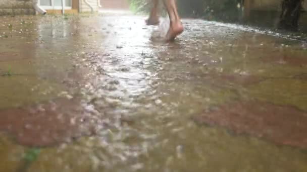 Καλοκαιρινή βροχή. Γυμνά πόδια τρέχει μέσα η λακκούβα. Ζεστή βροχή. Σταγόνες βροχής. 4k, αργή κίνηση — Αρχείο Βίντεο