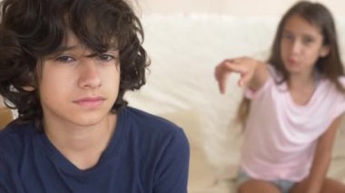 Gençler, İkizler, kardeşi ve kız kardeşi, kavga kanepede oturuyor. 4 k, ağır çekim, yakın çekim.