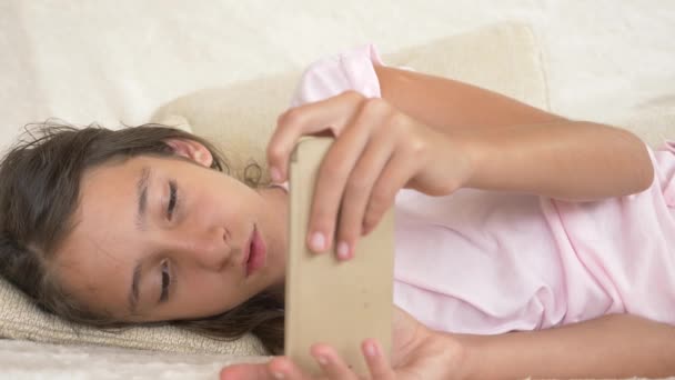 Adolescente mignonne dormant sur un canapé avec téléphone à la main. Manque de sommeil. gros plan, 4k — Video