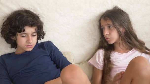 Tieners, twins, broer en zus ruzie, zittend op de Bank. 4 k, slow motion, close-up. — Stockvideo