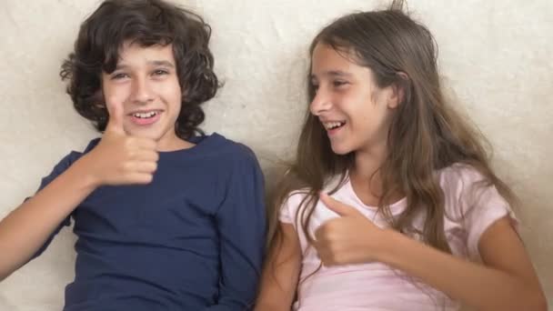 Retrato de adorable hermano y hermana, adolescentes sonriendo y riendo con expresión divertida en sus rostros. Felicidad y relaciones familiares. 4k, cámara lenta — Vídeos de Stock