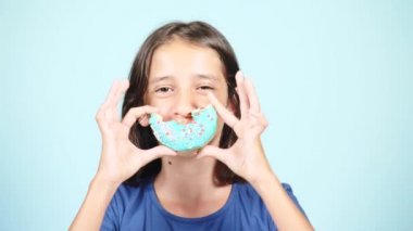 Portre. having oyunculuk ile renkli donut yüzüne karşı uzun tüyleri, komik bir kızla portresi. İfadeler, diyet kavramı, arka plan rengi