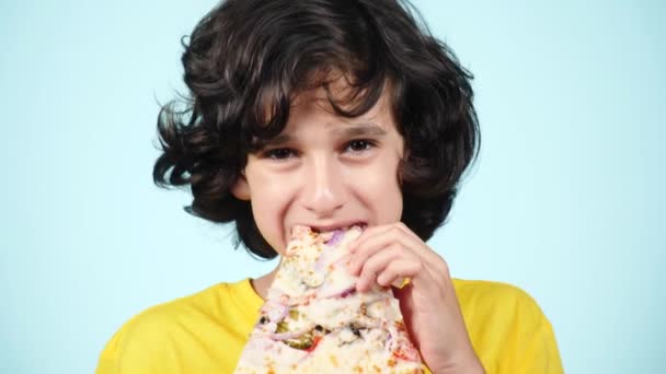 Pizza. Rapaz feliz adolescente segurando pizza. Conceito de comida. Pronto para comer. Homem encaracolado sorridente com pizza saborosa. Publicidade de pizzaria. no fundo azul. 4k câmera lenta — Vídeo de Stock