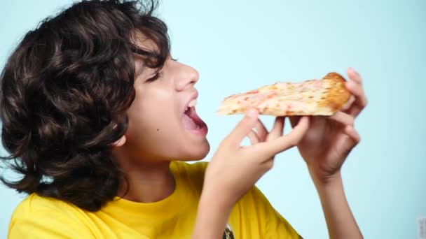 ピザ。幸せな少年ティーンエイ ジャー保持ピザ。食品のコンセプト。食べる準備ができて。おいしいピザと笑みを浮かべて巻き毛の男。ピザ屋の広告。青い背景。4 k スローモーション — ストック動画