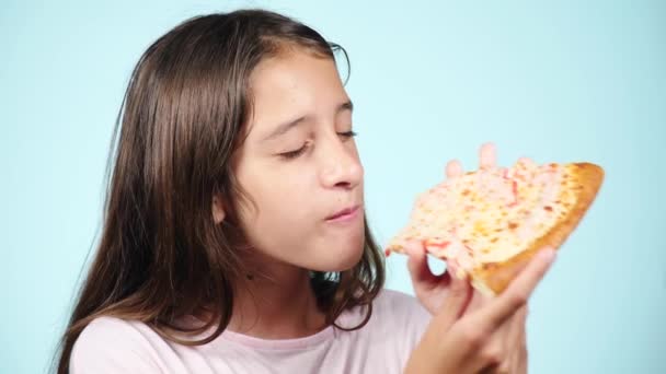 Pizza. Happy girl teenager holding pizza. Food concept. Ready to eat. Smiling girl with tasty pizza. Pizzeria advertising. on blue background. 4k slow motion — Stock Video