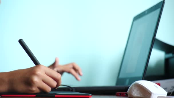 Close-up. Meisje teken op een grafisch tablet. Freelance. Een hand met een stylus verplaatsen op een rood zwart tablet. 4k, slow-motion. kleur achtergrond. kopie ruimte — Stockvideo