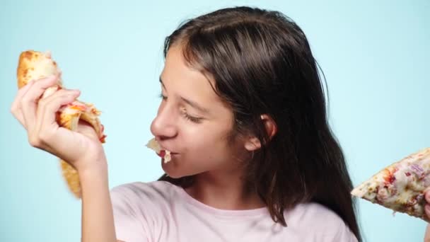 ピザ。幸せな少年ティーンエイ ジャー保持ピザ。栄養の概念。女の子は、ピザを食べています。おいしいピザと笑みを浮かべて巻き毛の男。広告のピッツェリア。青い背景。4 k スローモーション — ストック動画