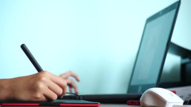 yakın çekim. Kız bir grafik tablet üzerinde çizin. Serbest. Bir el ile bir kırmızı siyah tablet üzerinde hareketli bir pikap iğnesi. 4k, ağır çekim. renk arka plan. kopya alanı