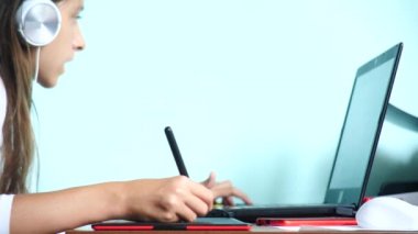 yakın çekim. Kız bir grafik tablet üzerinde çizin. Serbest. Bir el ile bir kırmızı siyah tablet üzerinde hareketli bir pikap iğnesi. 4k, ağır çekim. renk arka plan. kopya alanı