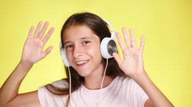 Genç kız renk arka plan üzerinde müzik dinlerken kulaklık ile. yakın çekim, 4k, ağır çekim.