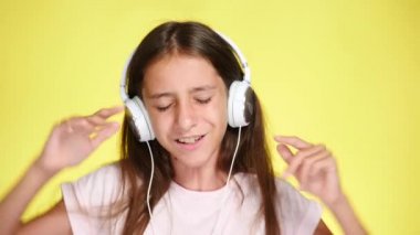 Genç kız renk arka plan üzerinde müzik dinlerken kulaklık ile. yakın çekim, 4k, ağır çekim.
