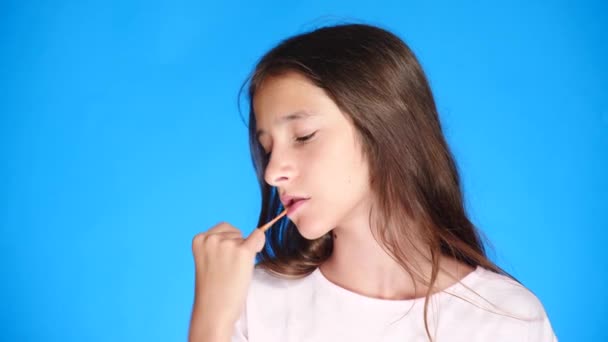 Meisje die zich uitstrekt van kauwgom op een gekleurde achtergrond. 4 k, close-up, slow-motion-video schieten. — Stockvideo