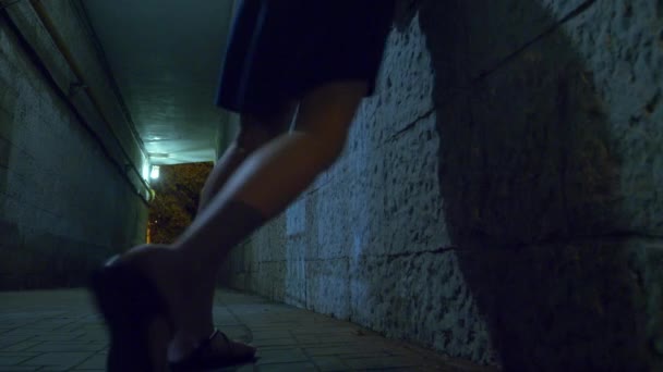 A drunken woman walks alone at night through a pedestrian tunnel. 4k. — Stock Video