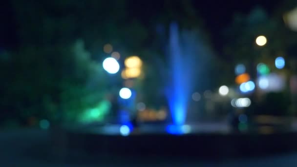 Una fuente con iluminación de agua de colores, por la noche. primer plano, desenfoque, 4k — Vídeo de stock