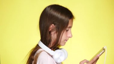 Genç kız mobil müzik renk arka plan üzerinde telefon ve kulaklık ile. yakın çekim, 4k, ağır çekim