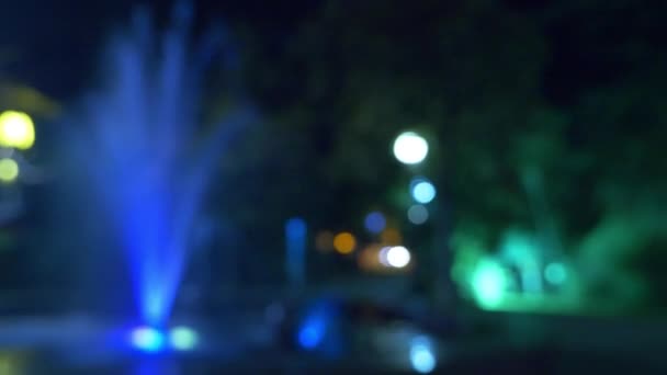Una fuente con iluminación de agua de colores, por la noche. primer plano, desenfoque, 4k — Vídeo de stock