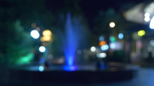 En fontän med färgat vatten belysning, på kvällen. närbild, oskärpa, 4k — Stockvideo