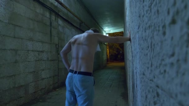 Ένας μεθυσμένος άντρας περπατά μόνος τη νύχτα μέσα από ένα τούνελ για πεζούς. 4k. — Αρχείο Βίντεο