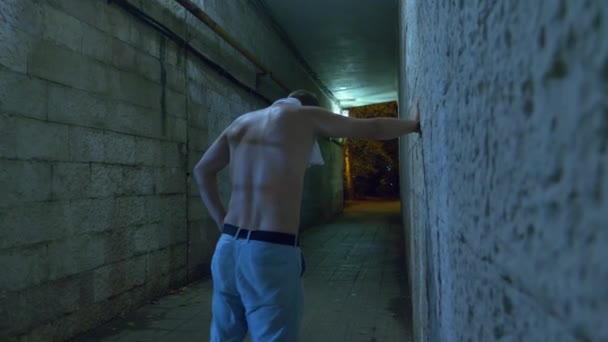 En berusad man går ensam på natten genom en gångtunnel. 4k. — Stockvideo