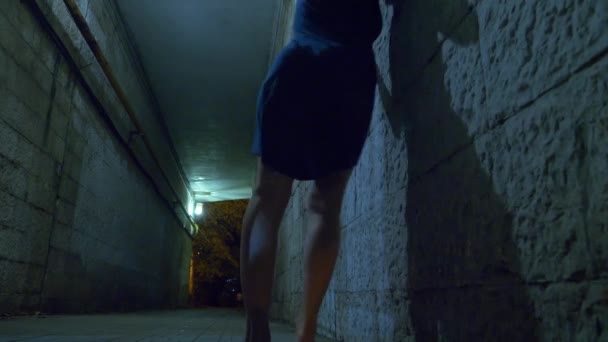 酒に酔った女性は歩行者専用トンネルを通って夜独り歩きます。4 k. — ストック動画