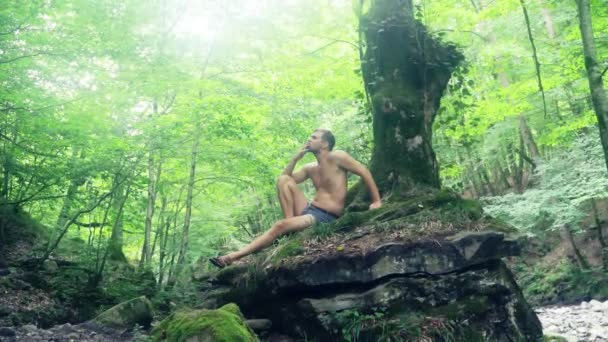 Pareja joven descansando en un parque bajo el árbol — Vídeos de Stock