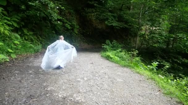 森林歩道に沿って森から来る美しい青いドレスの少女モデル。4 k、スローモーション. — ストック動画