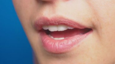 yakın çekim, kadın dudak makyaj, mavi bir arka plan olmadan. 4k, ağır çekim çekim. sürpriz duygu. Kapa çeneni, elle