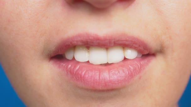 Close-up, lábios femininos sem maquiagem, em um fundo azul. 4k, câmera lenta — Vídeo de Stock