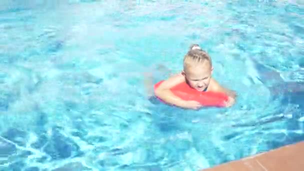 Ευτυχισμένη πανέμορφο κοριτσάκι στην εξωτερική πισίνα, επιπλέει στο Φουσκωτό μαξιλάρι. 4k, αργή κίνηση, — Αρχείο Βίντεο