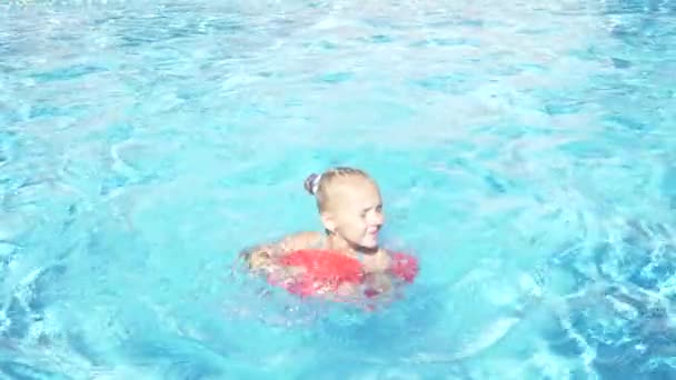 Boldog bájos kislány a kültéri medencében, úszó egyedül a felfújható párna. 4k, lassú mozgás, — Stock videók