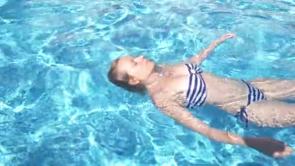 Açık havada su yalan bir mayo içinde genç güzel yatan kadın. 4k, ağır çekim — Stok video