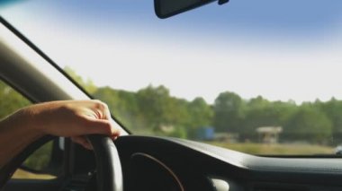 Adam arabasını. Arabayı. doğa. Direksiyon simidi üzerinde erkek el kapatın. güneş ışığı parlama 4k, ağır çekim