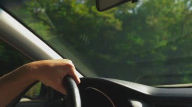 Adam arabasını. Arabayı. doğa. Direksiyon simidi üzerinde erkek el kapatın. güneş ışığı parlama 4k, ağır çekim
